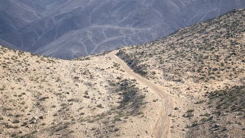 Scenic View of a Winding Dirt Road Through Rocky Mountain Landscape