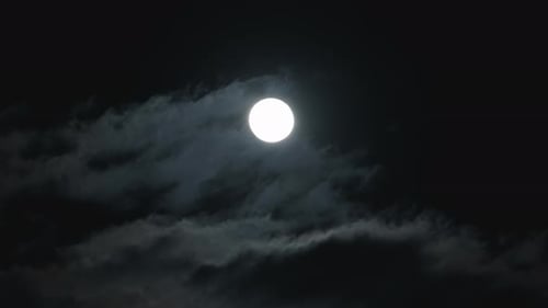 Bright Moon Shines Behind Clouds at Night