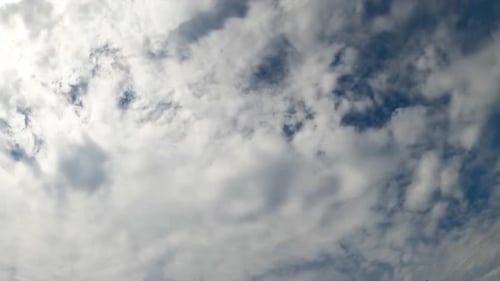 Stratus cloudscape covering the blue skies. Low angle view on the clouds gathering in the atmosphere