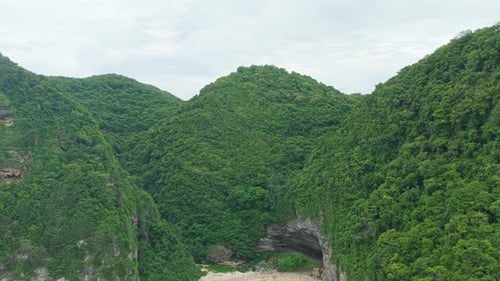 Drone flying towards secret tropical beach in nusa penida