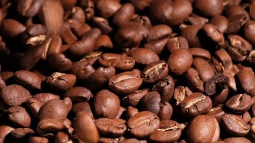 Wunderschöne Zeitlupenaufnahme fallender gerösteter Kaffeebohnen