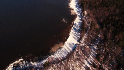 Vol par drone au-dessus de la mer en hiver Rochers gelés sur la côte. Mer avec vagues en hiver