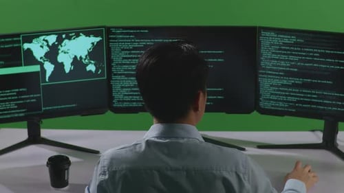 Back View Of Asian Man Developer Using Computer To Write Code With Multiple Screens In Green Screen