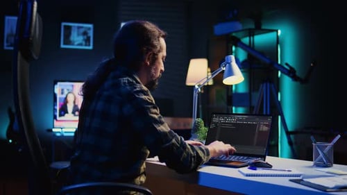 Programmierer schreibt Code auf den Laptop-Bildschirm, während er im Büro einer Wohnung mit Java ist