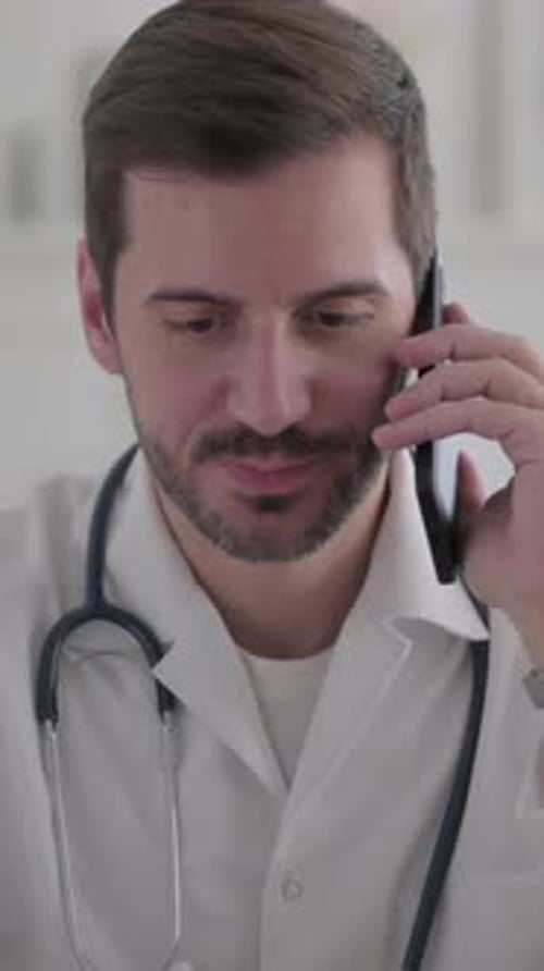 Doctor with Stethoscope Talking on Phone in Office