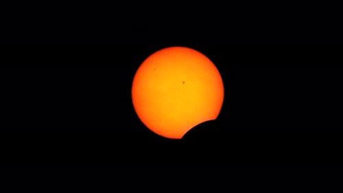 Das frühe Stadium einer totalen Sonnenfinsternis, in der der Mond beginnt, die Sonnenscheibe und zwei Sonnenstrahlen zu bedecken
