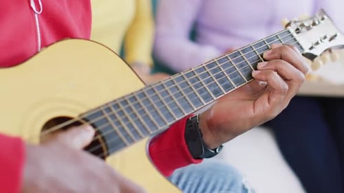 Person Playing Acoustic Guitar Close Up