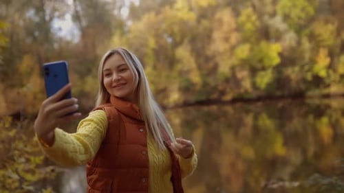 Happy Woman Taking Selfie in Colorful Autumn Park