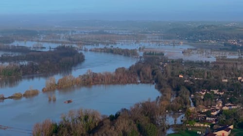 Aerial view of flooded vineyards reflecting the sky, with trees emerging from the water