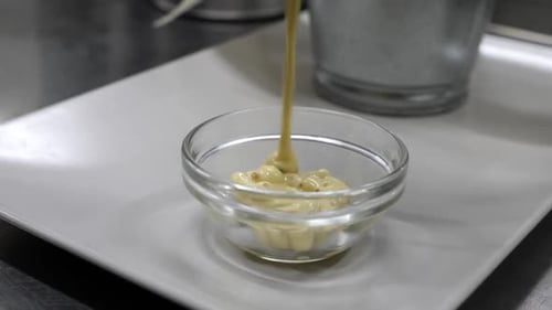 Pouring Gourmet Sauce into Bowl in Restaurant Kitchen