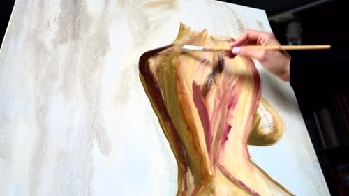 Beautiful woman painting with watercolors at an art gallery workshop