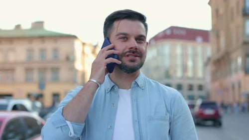 Caucasian Man Standing on Street and Smiling While Calling and Talking on Cellphone Happy Handsome