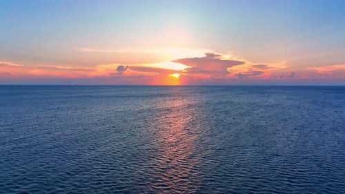 Drone aerial view of endless horizon over the sea in golden sunset. 4K.