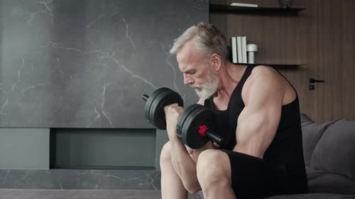 Senior Man Lifting Dumbbell in Home Setting