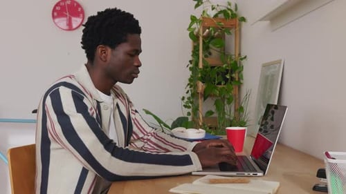 Young Student Black Man Typing on Laptop Studying Online at Home Office