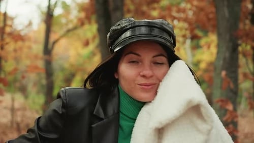 Woman in Autumn Park Smiles With Scarf