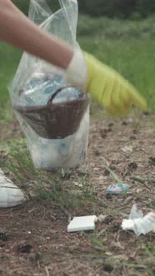 Una voluntaria recolecta basura al aire libre Una mujer dedicada participa en un esfuerzo comunitario para eliminar los desechos de