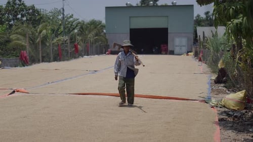 Farmer Walking with Tool in Rural Field