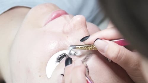 Eyelash Extensions Being Applied to Young Adult Woman