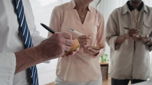 Los empleados colocan pegatinas con ideas en un papel al planificar la jornada laboral