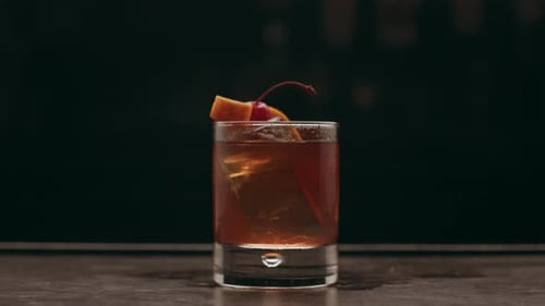 Craft cocktail close up on a bar in dramatic lighting for upscale advertising