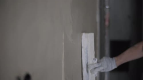 Worker Plastering Interior Wall with Trowel