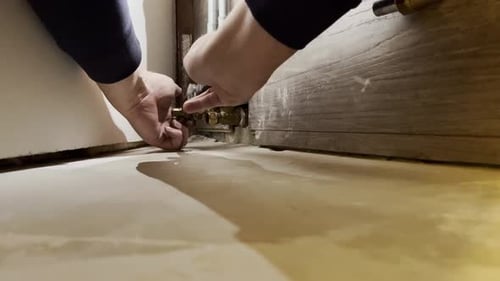 Male Hands Tightening Pipe Fitting Locknuts With Crescent Wrench. closeup