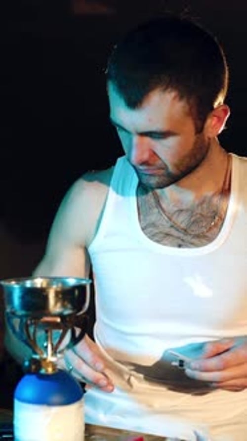 Man Prepares Equipment on Table Indoors