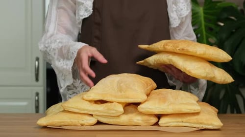 Ready-made homemade bakery products. Woman baking pastry and buns in her home kitchen