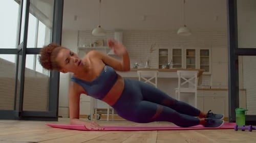 Active Sporty Fit African Woman Practicing Side Plank Yoga Exercise Indoors
