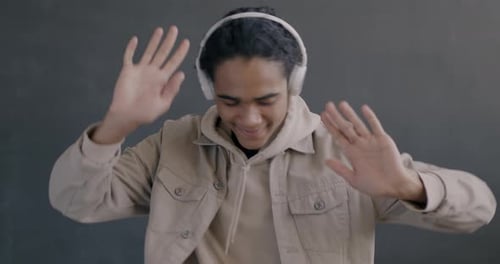 Enthusiastic Young Adult Dancing with Headphones