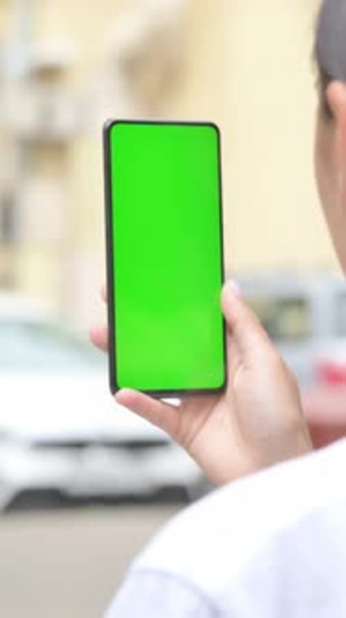 Hispanic Woman Using Phone with Green Screen Outdoor, vertical