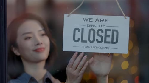 Asian smiling woman owner flipping sign "Closed" to "open" store for ready to serve service through