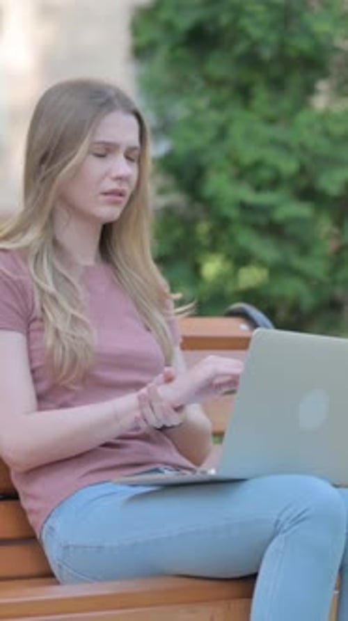 Woman Typing on Laptop Outside on Park Bench