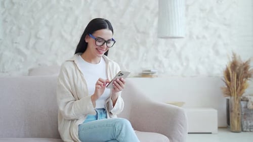 Young Woman Reacts to Good News on Smartphone