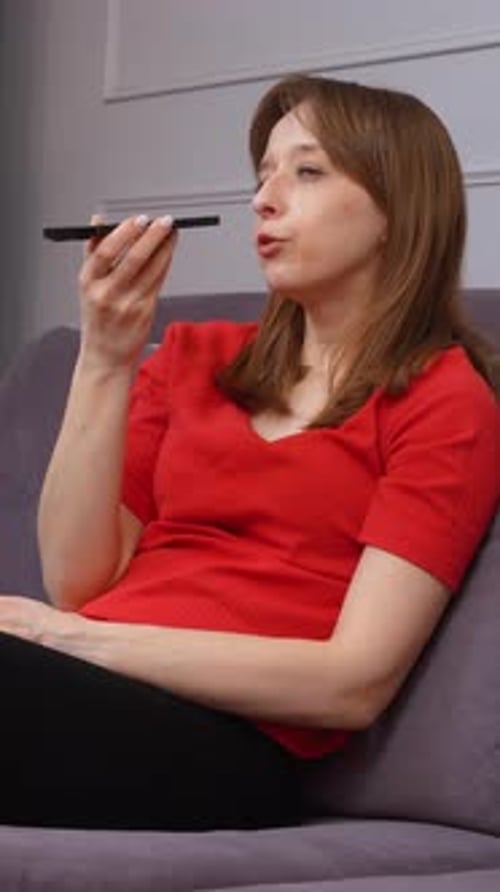 Young Woman Talking on Phone Sitting on Sofa