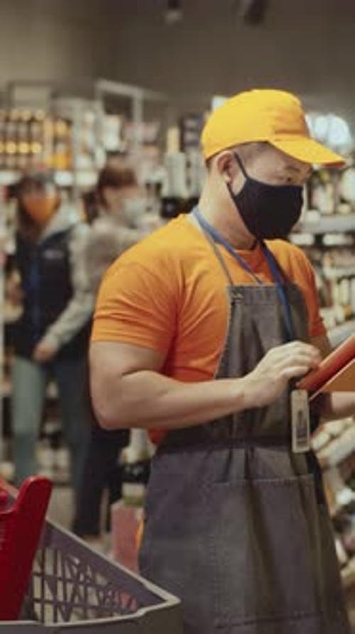 Employee Using Tablet in Retail Store Aisle