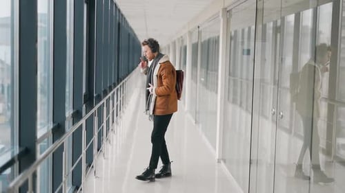 Stylish cheerful man dancing in headphones in the hallway