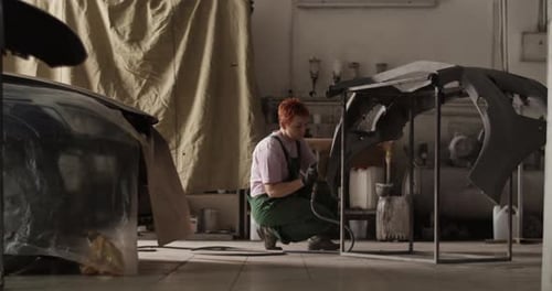 Mechanic Repairs a Car in a Spacious Workshop