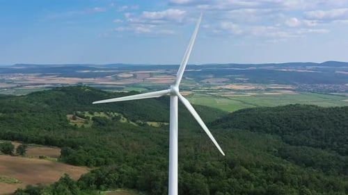 Aerial view to rotor blades of wind turbine in wind park on the hill