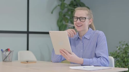 Blonde Woman on Tablet Video Call at Desk