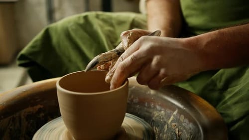 Poterie : peinture d'un potier au pinceau, peinture d'un pot rotatif, faïence artisanale sur potier