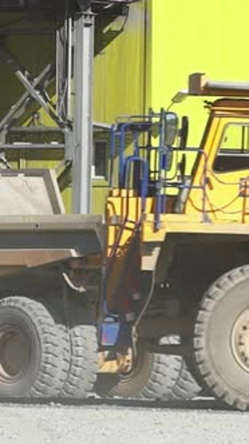 Yellow Dump Trucks Idling at Construction Site