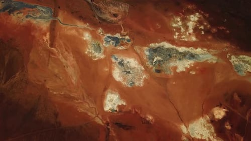 Aerial view of the bright red and orange textured ground at the geothermal area of Hverir, Iceland