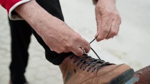 Person Tying Leather Boots