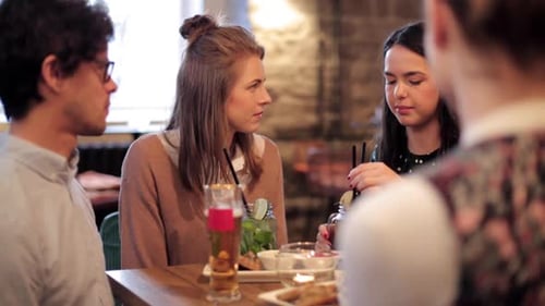 Friends Chatting at a Cafe Over Drinks