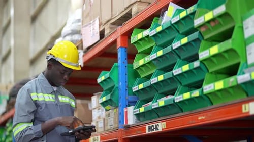 Warehouse Industrial and Logistics Companies. Dispatcher in uniform making inventory in storehouse.