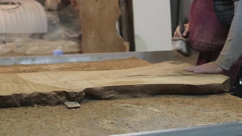 Woodworker Smoothing Large Wood Slab in Workshop