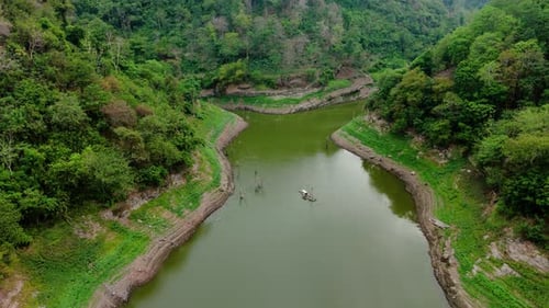 Drone view of green lake with forest land