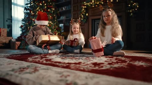 Children Opening Christmas Gifts at Home